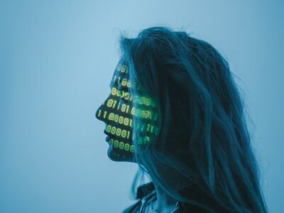woman looking to the left with binary code projected over her face