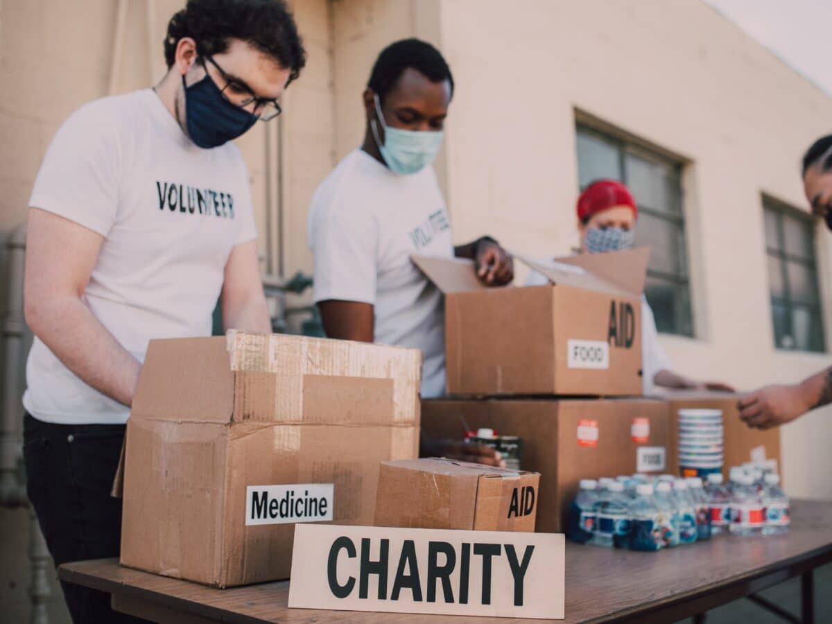 volunteer workers for a charity handing out boxes of supplies